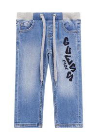 Pantalones jogger de mezclilla en azul claro con una cintura acanalada gris, cordones y el logotipo bordado en negro "GUESS" en el lateral.
