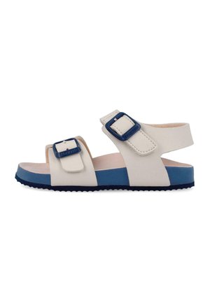 Sandalia de punta abierta blanca y azul con tiras ajustables y hebillas, suela plana, diseñada para uso casual.