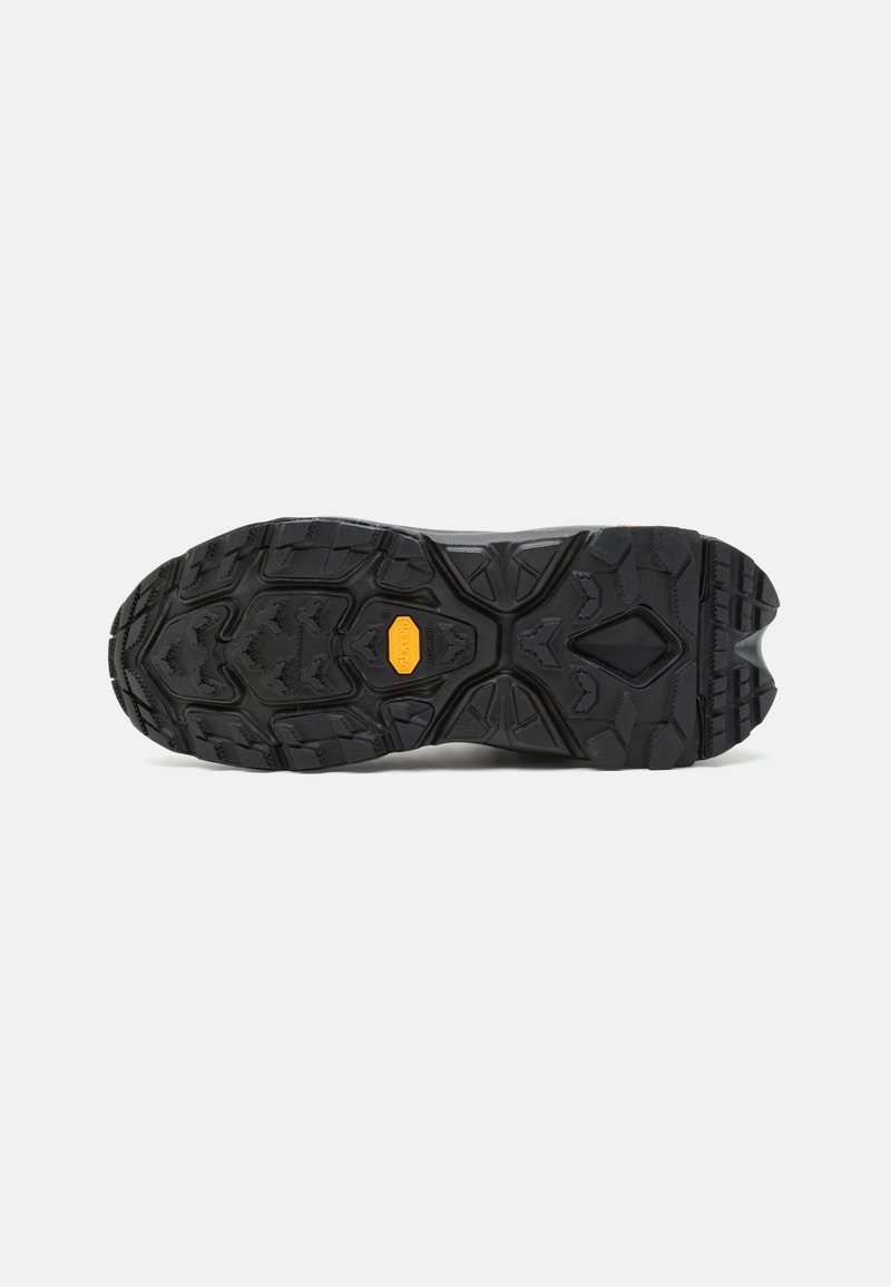 Black rubber outsole with deep tread patterns and a prominent orange logo. Sturdy design for enhanced traction on various surfaces.