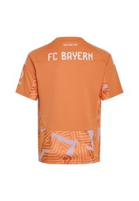 Oranges FC Bayern Sporttrikot mit geometrischen Mustern, weißem Text "FC BAYERN" und "MIA SAN MIA" auf dem Rücken und Logos auf den Ärmeln.