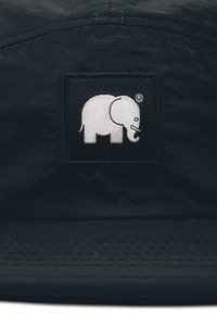 Čierna čiapka s nášivkou bieleho vyšitého loga slona. Tkanina vyzerá textúrovaná a odolná, s plochým šiltom.