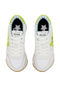 Baskets blanches avec une tige en cuir lisse, des accents vert vif, et une semelle extérieure en caoutchouc gomme. L'intérieur est doublé d'un tissu rayé bleu avec logo.