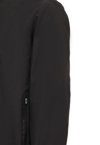 Jachetă neagră ușoară cu o textură netedă, având un buzunar cu fermoar pe lateral și un design minimalist. Fără ornamentații vizibile.