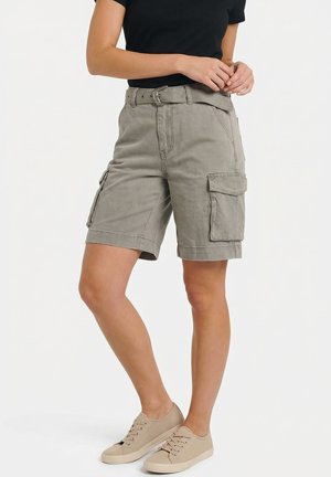 Pantaloncini cargo grigi di lunghezza media con passanti per cintura e tasche laterali, indossati con sneakers beige e una maglietta nera, mostrati dalla metà coscia fino alla vita.
