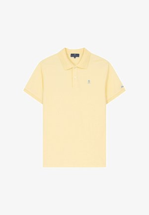 Polo de manga corta de color amarillo pálido con cuello, tapeta de dos botones, pequeño logo azul de palos de golf cruzados en el lado izquierdo del pecho y bordado en la manga.