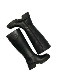 Czarne skórzane kozaki do kolan z płaską, masywną podeszwą, z zamkiem po wewnętrznej stronie i okrągłym logo po zewnętrznej stronie.