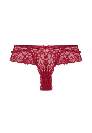Tanga de encaje rojo con patrón floral, bordes con ondas y un detalle de lazo en la parte delantera. Material delicado y transparente con una textura suave.