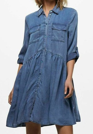 Robe chemise en denim à manches longues, boutonnée sur le devant, avec deux poches poitrine, taille froncée et jupe fluide dans un ton bleu clair.