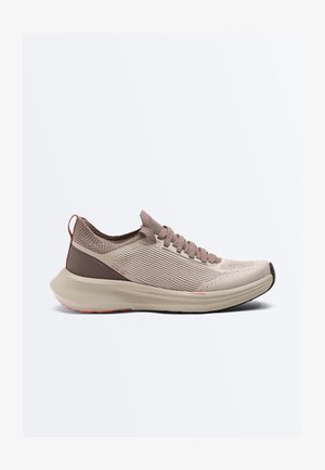 Lys brun atletiksneaker med strikket overdel, tyk polstret sål, snørelukning og trækstrop ved hælen, vist i sideprofil på hvid baggrund.