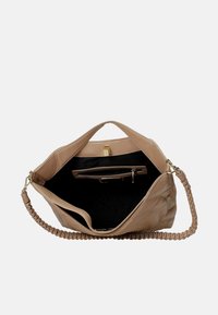 Borsa a mano color beige chiaro con esterno testurizzato, che mostra un interno aperto foderato in nero, dotata di una tasca con zip e manico intrecciato.