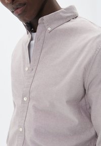 Cămașă button-up de culoare violet deschis, realizată din material țesut, având un guler clasic și detalii de cusătură subtile de-a lungul nasturilor.