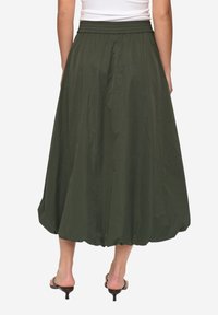 Zielona spódnica do kostek o oliwkowym odcieniu, z obszernym fasonem, elastycznym pasem i gładką fakturą, odpowiednia do codziennego noszenia.