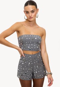 Ensemble gris en deux pièces comprenant un crop top bustier et un short taille haute, orné de sequins ronds métalliques et d'accents décoratifs.