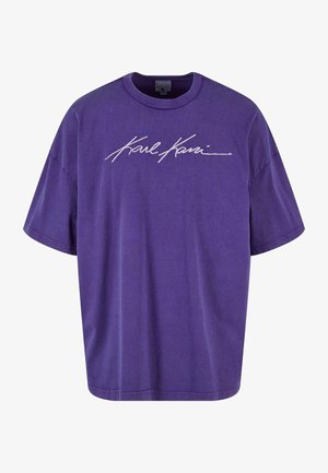 Violetinio medvilninio marškinėlių su apvaliu kaklu ir trumpomis rankovėmis. Priekyje yra baltas, užrašytas „Karl Kani“ logotipas.