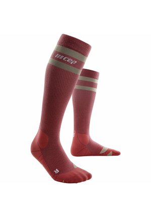 Compressiesokken in diep rood met lichtbeige strepen, voorzien van ribbels, versterkte teen- en haksecties, en logo detail.