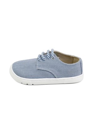 Zapato casual de lona azul claro con suela blanca y cordones a rayas azules y blancas, mostrado de perfil sobre fondo blanco.