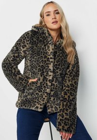 Dress i leopardmönster av konstpäls med huva, som har en mjuk textur, långa ärmar och framfickor. Färgpaletten inkluderar beige och svart.