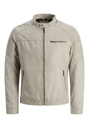 Light beige jacket made of soft, textured fabric. Features a zip front, stand collar, quilted shoulder accents, and zippered pockets.