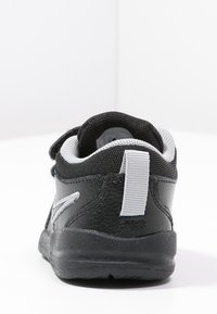 Černé tenisky s šedými akcenty, síťovaným svrškem, polstrovaným límcem a strukturovanou gumovou podrážkou. Obsahují textilní poutko na patě.