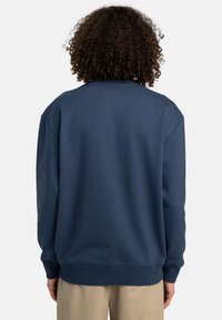 Navy blue sweatshirt with a crew neckline, dropped shoulders, and ribbed cuffs. Soft fabric, casual fit, plain texture, and no visible logos.