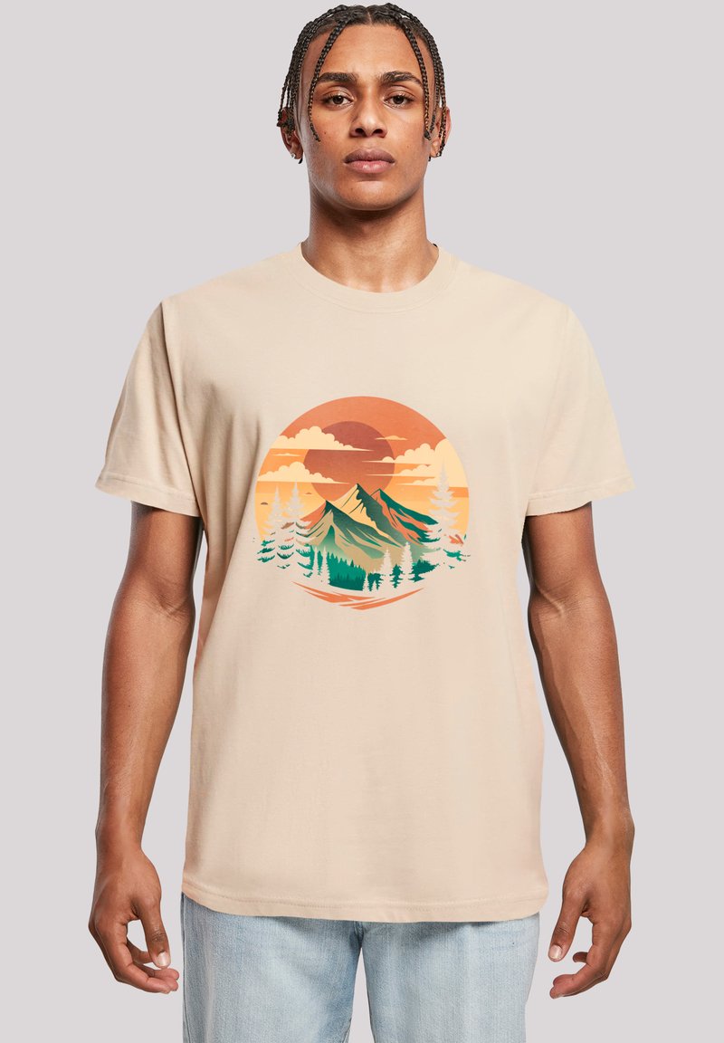 Beige cotton t-shirt featuring a mountain and forest graphic in green, orange, and yellow, with short sleeves and a relaxed fit.