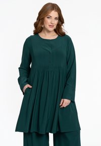 Türaqua, langärmliges Tunika-Kleid mit einem runden Halsausschnitt, das eine geraffte Taille, Knopfdetails und seitliche Taschen aufweist. Weicher, glatter Stoff.