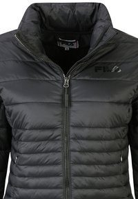 Giacca puffer nera imbottita con colletto alto, chiusura con zip e imbottitura orizzontale. Presenta il logo FILA sul petto e una tasca laterale.
