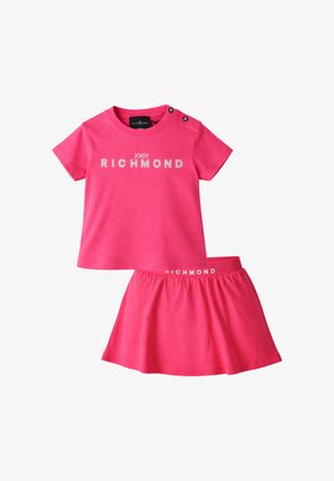 Camicia rosa acceso a maniche corte con scritta "John Richmond" e gonna coordinata con cintura elastica, entrambe realizzate in tessuto morbido.