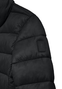 Giacca nera imbottita con sezioni trapuntate e una finitura testurizzata. Include una patch con logo testurizzato sulla parte superiore del braccio.