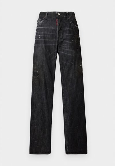 Jean en denim noir à coupe décontractée, avec des patchs déchirés et de discrètes éclaboussures de peinture. Plusieurs poches et fermeture à bouton.