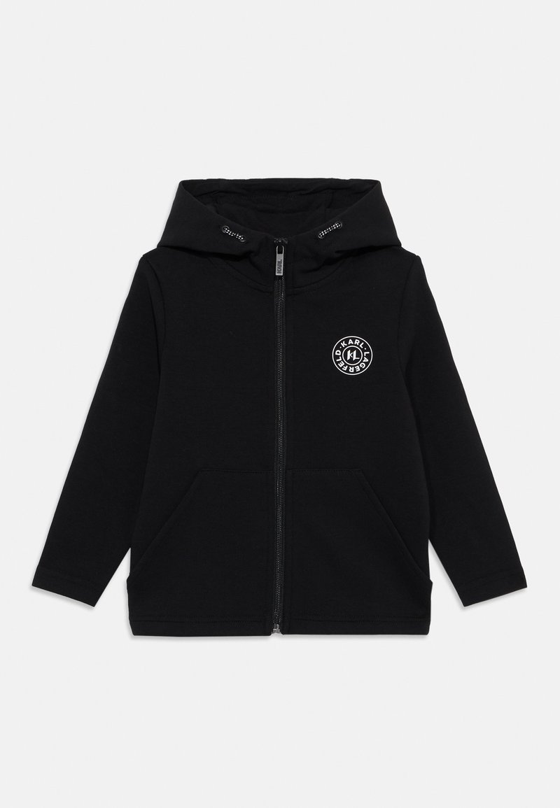 Hoodie zippé noir avec une grande capuche, deux poches avant et un logo circulaire blanc sur la poitrine gauche. Fabriqué en tissu doux.