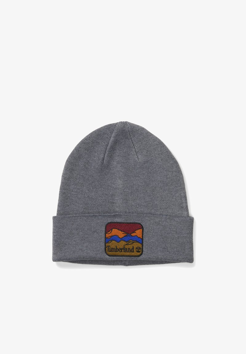 Bonnet en tricot gris avec un revers replié et un patch coloré brodé représentant des montagnes et le logo Timberland. Texture douce.