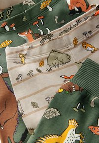 Quatre paires de pantalons pour enfants avec des imprimés ludiques sur le thème des animaux et de la nature. Tissus en vert, beige et marron avec des illustrations détaillées.