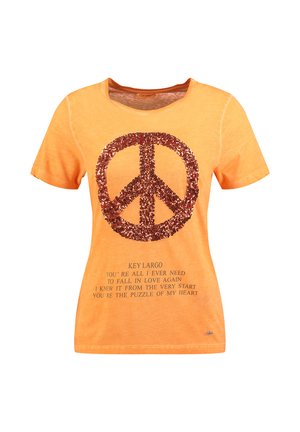 Chemise orange à manches courtes avec un grand symbole de paix en sequins rouges et un texte sur l'amour et les cœurs imprimé en dessous.