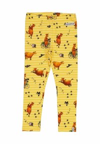 Keltaiset leggingit, joissa on leikkisä lehmäkuvio, jossa lehmiä pyöräilemässä, mustia jalanjälkiä ja raidoitettu tausta.