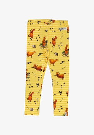 Yellow leggings featuring a playful cow print, including cows riding bicycles, with black footprints and a striped background.