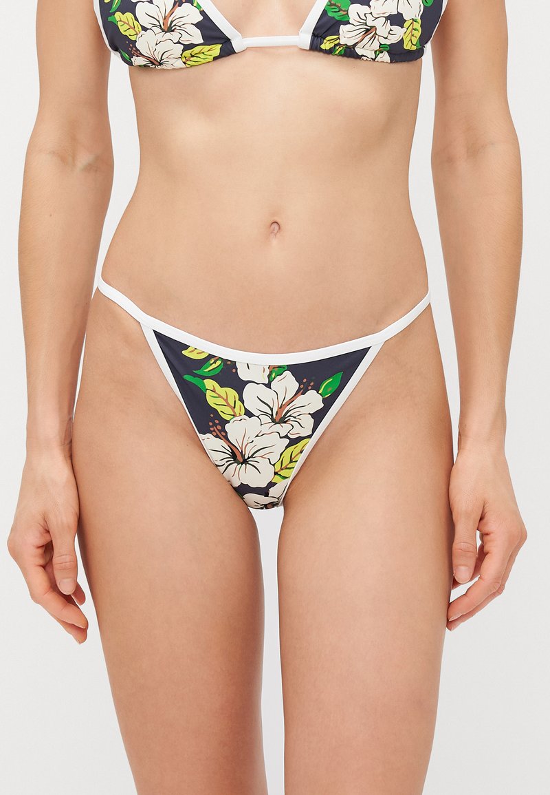 Floral bikini set featuring a navy background with large white hibiscus flowers and green leaves. Finished with white trim and thin straps.