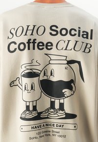 Deux tasses de café et une cafetière en cartoon souriantes, portant des baskets, avec le texte "SOHO Social Coffee CLUB" et "Bonne journée" avec une adresse à New York.