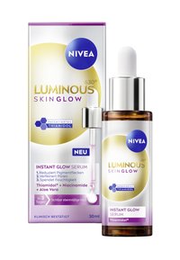 NIVEA Luminous Skin Glow Serum in einer braunen Glasflasche mit einem silbernen Tropferdeckel. Die Verpackung weist lila und goldene Akzente auf. 30ml Größe.