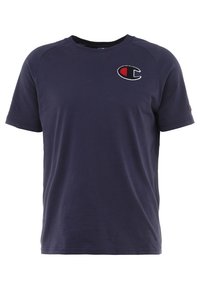 Námořnická modrá tričko s krátkým rukávem, kulatým výstřihem a malým logem Champion v červené, bílé a černé barvě na levé horní části hrudníku.