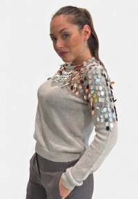 Maglione grigio chiaro con finitura strutturata, caratterizzato da paillettes circolari in tonalità di argento, bronzo e oro lungo le spalle.
