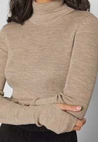 Beige ribbad polotröja med långa ärmar, med tumhål, texturerat tyg och figurnära passform. Passar bra för lager-på-lager-styling.