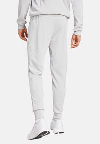 Hellegraue Sport-Jogginghosen mit einer figurbetonten Passform, tapered Beinen und strukturiertem Stoff; verfügen über gerippte Bündchen und Einsatzakzente.