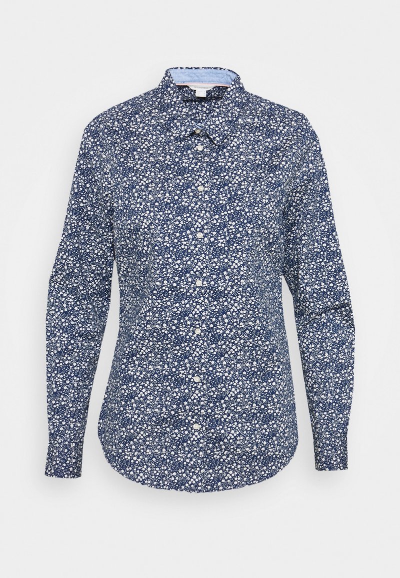 Chemise à manches longues boutonnée avec un fond bleu marine et un petit imprimé floral blanc, col classique et ourlet arrondi.