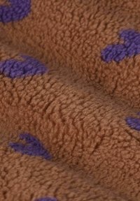 Tissu en polaire marron avec une surface texturée, comportant des motifs de cœurs violets dispersés. Apparence douce, chaude et confortable.