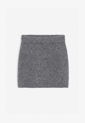 Mini gonna grigia lavorata a maglia con una vita a coste, caratterizzata da accenti di perline metalliche sparse per aggiungere texture e interesse visivo.