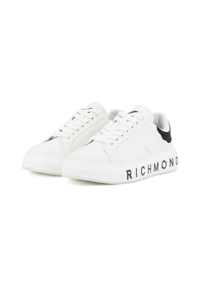 Witte lage sneakers met zwarte hieldetail en "RICHMOND" tekst op de buitenzool, vetersluiting, naast elkaar geplaatst op een witte achtergrond.