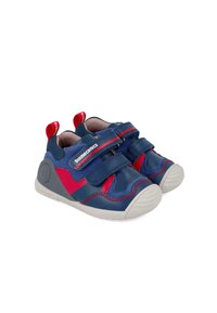Zapatos de cuero para niños en azul y rojo con dos correas de Velcro, suelas de goma, punteras redondeadas y detalle de costura en contraste.