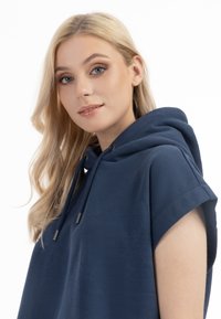 Granatowy hoodie z krótkimi rękawami, z trokiem przy szyi i miękką teksturą. Posiada minimalistyczny design bez widocznych wzorów.