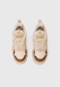 Bež tenisice s teksturiranom mrežicom i smešnim kožnim detaljima. Okrugli vezice i podstavljeni ovratnik pružaju udobnost.